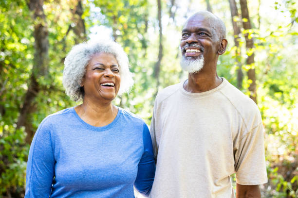 An active senior black couple hiking in the woods